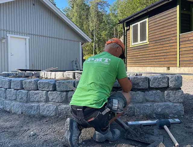 Hantverkare från Paulsson mark och trädgård, med grön t-shirt och svarta byxor.